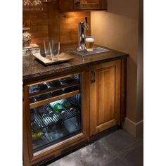 an open refrigerator with two glasses and bottles in it next to a counter top filled with drinks