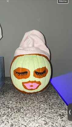 a pumpkin with a face painted on it and a towel wrapped around it's head