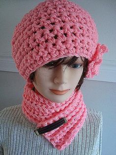 a mannequin wearing a pink crocheted hat and scarf