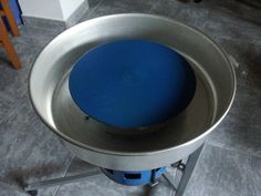 a blue stool sitting on top of a metal table