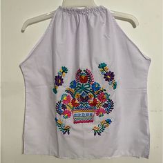 Artisanal Mexican Summer Blouse Whit Elastic Collar No Sleeves .Color Light Lilac White Multicolor Embroidered. Size L-Xl . 27” Long From Neck To Bottom. And 14” Wide From The Chest . Material Poplin. New No Tags. Multicolor Folk Style Tops For Beach, Multicolor Folk Tops For Beach, Sleeveless Tops With Multicolor Embroidery For Vacation, Sleeveless Top With Multicolor Embroidery For Vacation, Sleeveless Multicolor Embroidered Top For Vacation, Sleeveless Multicolor Embroidered Blouse For Vacation, Folk Multicolor Beach Tops, Casual Multicolor Sleeveless Embroidered Top, Sleeveless Festival Blouse With Multicolor Embroidery