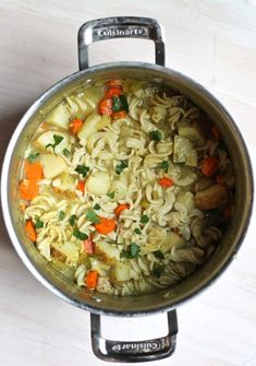 a pot filled with pasta and vegetables on top of a table