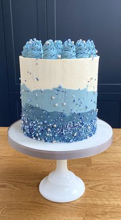 a blue and white cake sitting on top of a wooden table