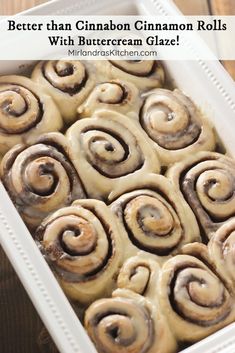 a pan filled with cinnamon rolls sitting on top of a wooden table