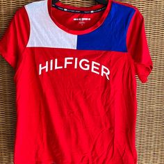 Tommy Hilfiger T Shirt. Unisex. In Excellent Shape. Never Worn. Trendy Red T-shirt With Logo Print, Tommy Hilfiger Graphic Tee With Graphic Print, Tommy Hilfiger Graphic Print Tee, Sporty Tommy Hilfiger Tops With Graphic Print, Trendy Tommy Hilfiger Cotton T-shirt, Tommy Hilfiger Sporty T-shirt For Summer, Tommy Hilfiger Sporty Summer T-shirt, Tommy Hilfiger Graphic Tee With Crew Neck, Tommy Hilfiger Graphic Print Short Sleeve Shirt