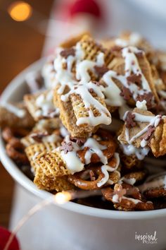 a white bowl filled with cheetos covered in chocolate and marshmallows