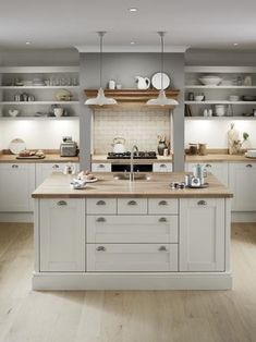 a large kitchen with white cabinets and wood flooring is pictured in this image from the front view