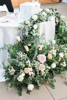 flowers and greenery are laid out on the ground