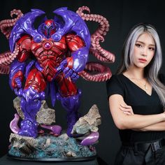 a woman standing next to a purple and red statue