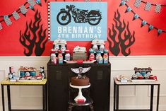 a motorcycle themed birthday party with cake and decorations on the buffet table, along with an ice cream cart