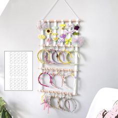 there is a wall hanging rack with many pairs of bracelets on it and a potted plant in the corner