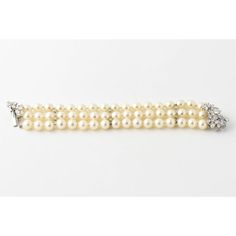 Perfect piece to wear with a gown or a suit, this impressive cultured pearl bracelet has three strand of pearls ranging from 8.9 mm to 9.10 mm.  The push button clasp has approximately 4.5 carats in fine white VS to SI stones  The diamonds are mounted in 14k white gold.  The pearls are accented with 3 gold bars decorated with 2 diamonds each. Strand Of Pearls, Cultured Pearl Bracelet, Gold Bars, White Gold Bracelet, Gold Bar, Push Button, Cultured Pearls, Pearl Bracelet, Diamond White