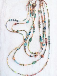 Three designs packed with rich jeweltone color...like turquoise, orange, copper, champagne, purples, several greens, teals,yellows, golds, rust, and desert coral. Tons of texture and interest. A variety of gemstones including Opal, Larimar, Apatite, Rhodonite, Turquoise, Amthyst, Citrine, Quartz, Sunstone, Jade, Pearls, Pyrite, several Agates and Jaspers, and more. Mix in Ancient Roman Glass, fused glass, recycled glass, Java Glass, Lampwork, rustic wood, bone disks, Czech beads, seed beads, and Fan Necklace, Orange Copper, Double Layer Necklace, Ancient Roman Glass, Glass Lampwork, Roman Glass, Bone Beads, Ancient Romans, Czech Beads