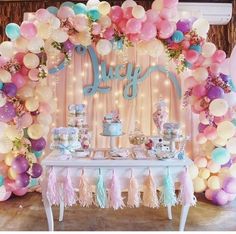 a table topped with lots of balloons and cake