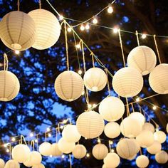 white paper lanterns hanging from the ceiling with string lights