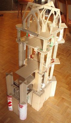 a model of a house made out of cardboard on a hard wood floor in a living room