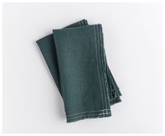 two dark green linen napkins folded on top of each other