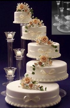 three tiered wedding cake with flowers and champagne glasses on the table next to it