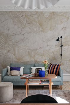 a living room with a couch, coffee table and lamp on top of the floor