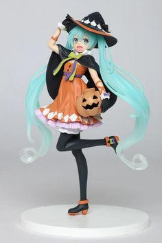 a figurine is holding a jack - o - lantern and wearing a witches costume