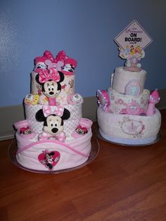 two cakes decorated with minnie and mickey mouses on top of each other in the shape of diapers