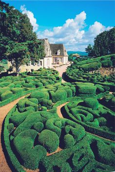 a large house surrounded by lush green hedges