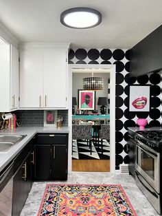 a kitchen with black and white wallpaper and rug