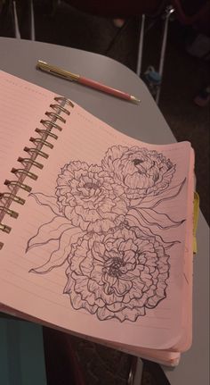 an open notebook with flowers drawn on it