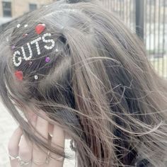 a close up of a person's hair with the word guts written on it