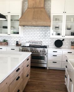 a kitchen with white cabinets and wood flooring is seen in this image from the front view