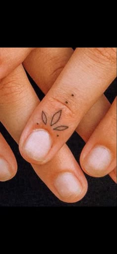 three fingers with small tattoos on them