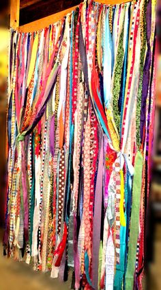 an assortment of colorful scarves hanging from a rack