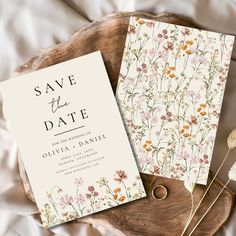 wedding save the date cards on a wood slice with dried flowers and twine pins