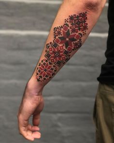 a man's arm with a cross tattoo on the left side of his arm