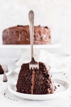 a piece of chocolate cake on a plate with a fork sticking out of the top