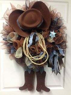 a cowboy wreath is hanging on the door