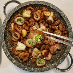 a bowl filled with meat and vegetables on top of a table