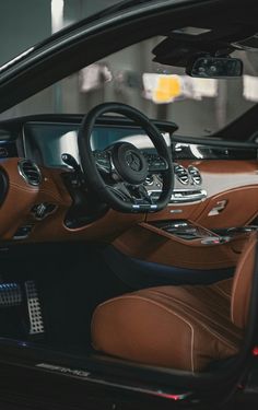 the interior of a luxury car with brown leather and black trims is seen in this image