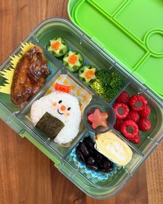 a bento box filled with different types of food on top of a wooden table