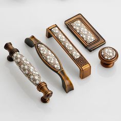 an assortment of decorative knobs and pulls on a white surface, including one with diamonds