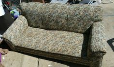 a couch that is sitting on the sidewalk