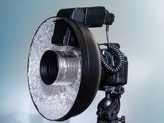 a tripod mounted to the side of a wall with a light on it's head