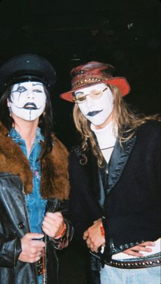 two people with painted faces standing next to each other