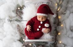 a newborn baby wearing a santa hat and sleeping in a box surrounded by christmas lights