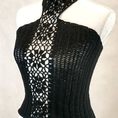 a mannequin wearing a black and white top with lacy crochet on it