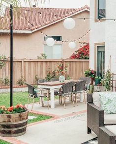 an outdoor patio with chairs, table and potted plants