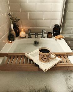 a cup of coffee sitting on top of a wooden tray in front of a sink