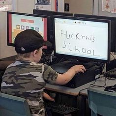 a young boy sitting at a desk using a computer