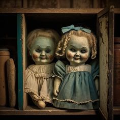 two creepy looking dolls in a wooden box