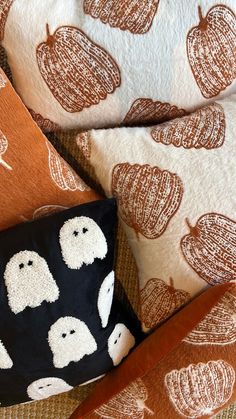 three pillows with pumpkins on them and one pillow has ghost faces printed on it